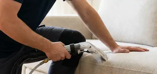 Professional upholstery cleaner deep-cleaning a fabric sofa with a handheld extraction tool, South Bend, IN.